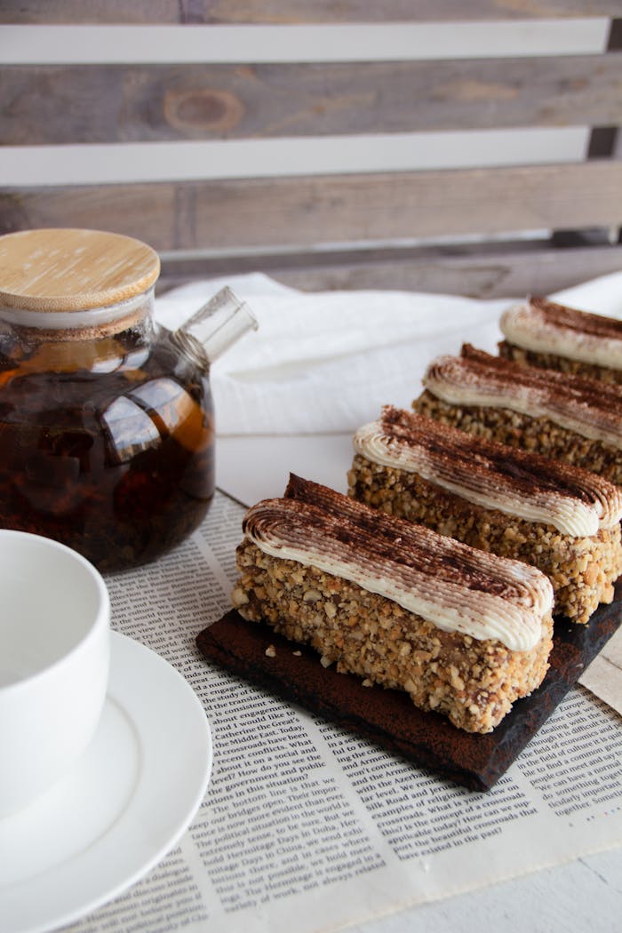 hero-img-02 Elegant presentation of nut-covered cakes paired with fresh brewed tea.